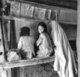 Iran/Persia: Rug-weaving woman with two young girls, Hamadan, c.1920